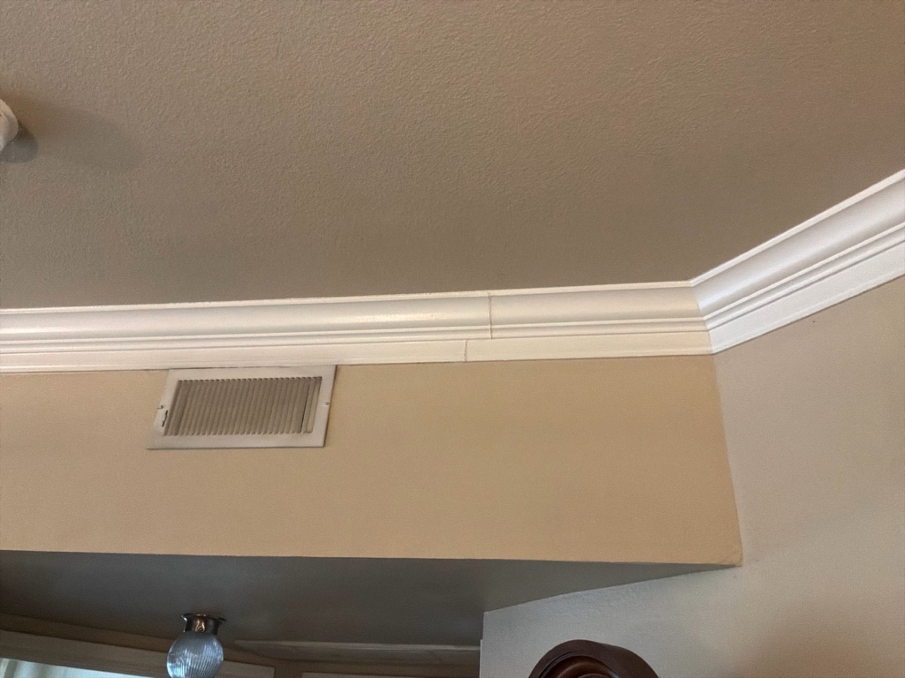 Crown-molding separation at the ceiling line — another interior fingerprint of movement