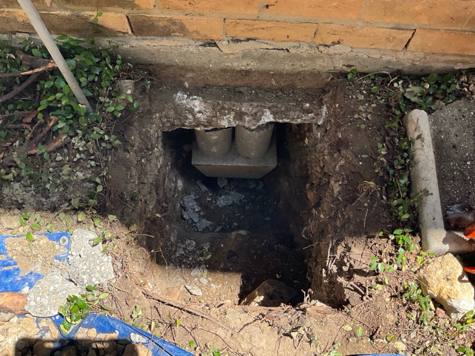 Hybrid pier cylinders pressed beneath the grade beam at an exterior access hole