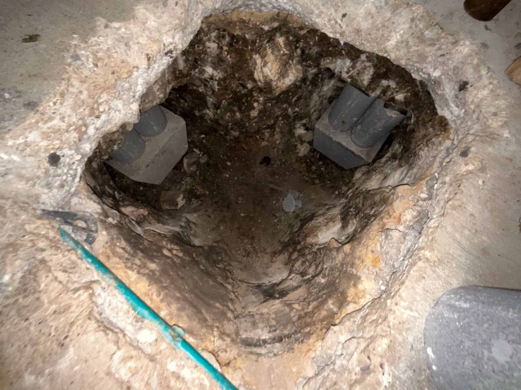 Interior slab access — piers installed beside the water lines the crews logged