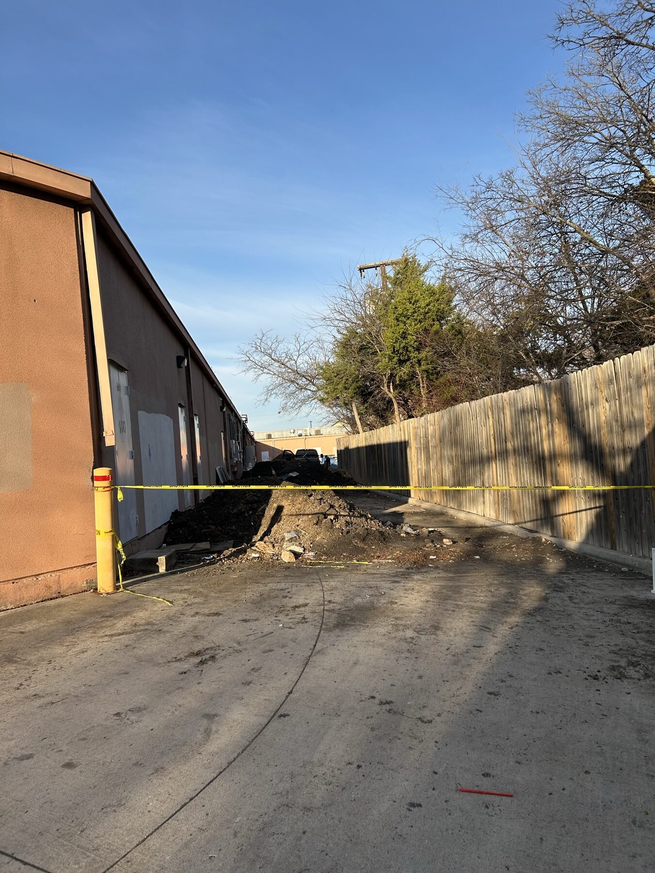 Rear-alley staging taped off, with delivery clearance maintained